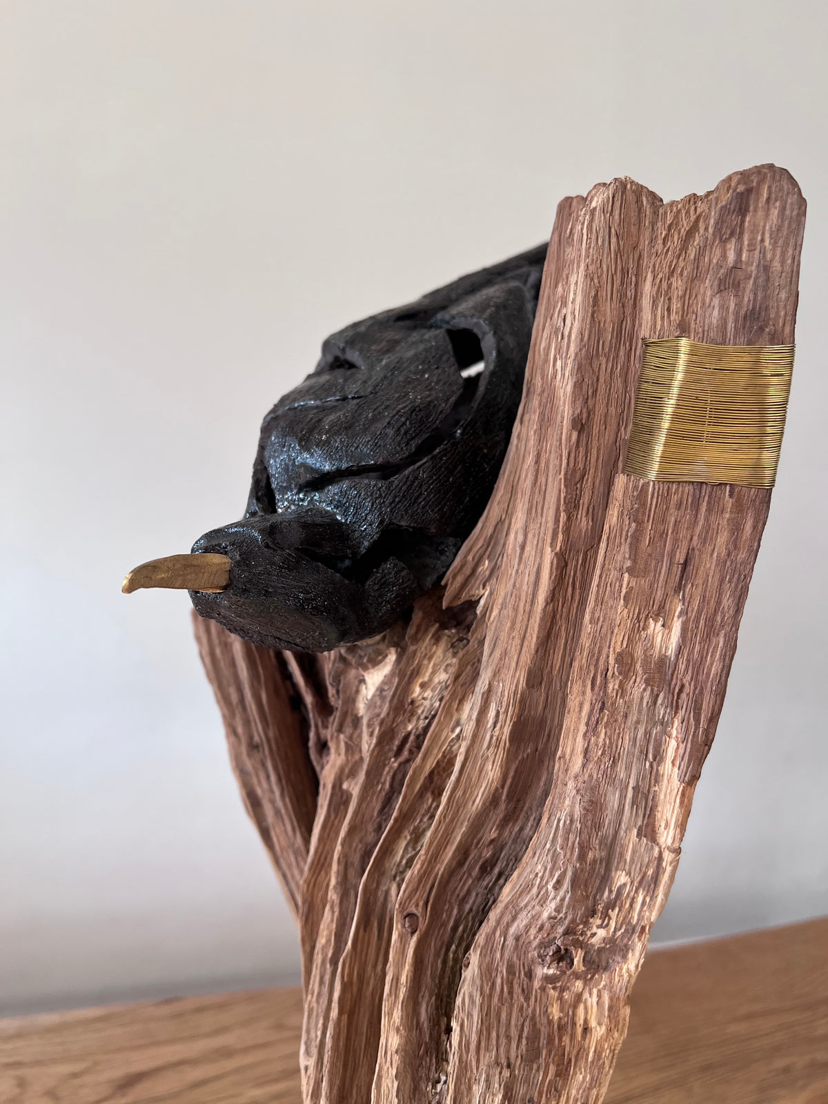 Kraai op hout met messing en steen